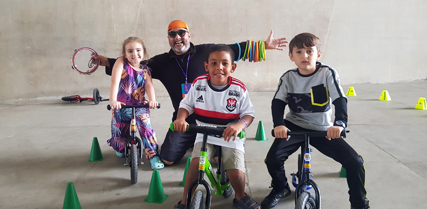 Fábio Nazareth com crianças praticando os Jogos de Bicicleta.